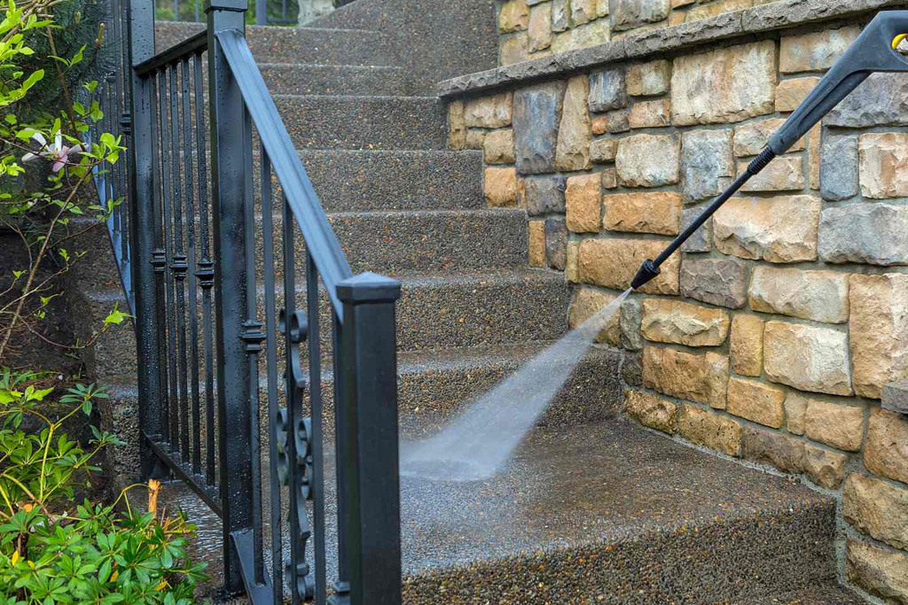 Pressure washing service in Coeur d'Alene, Idaho, rejuvenating a driveway with high-pressure water spray.
