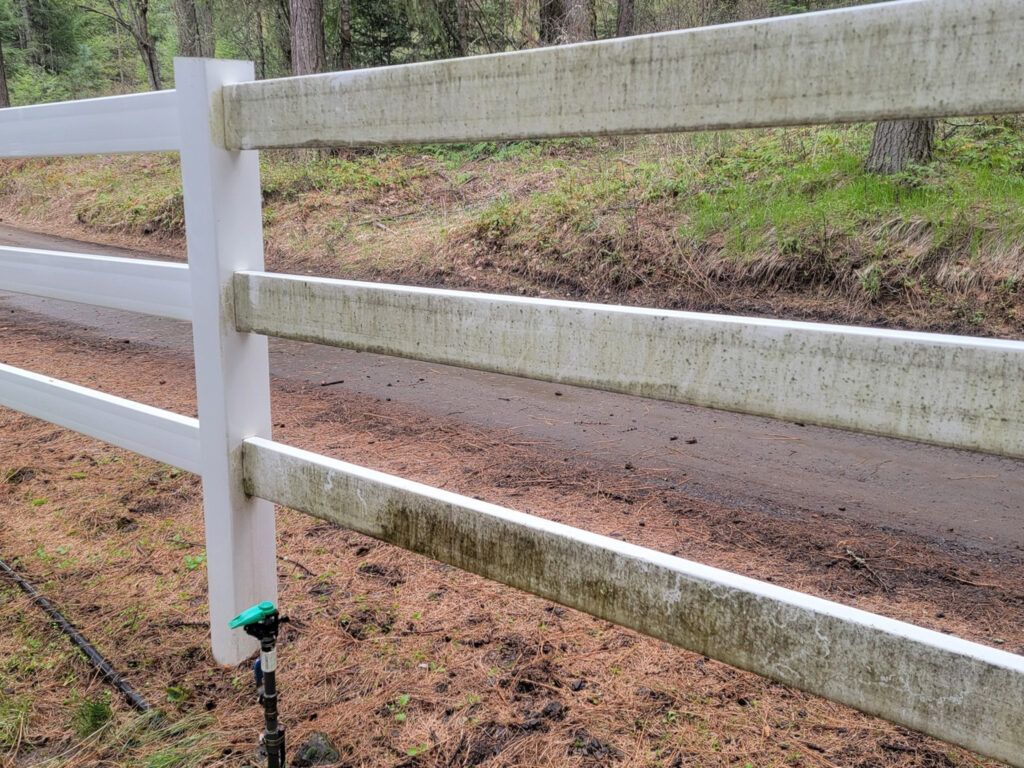 Pressure washing exterior of a lakefront home near Coeur d'Alene, ID, by Bullseye Wash Systems, cleaning surfaces and restoring the home’s appeal.