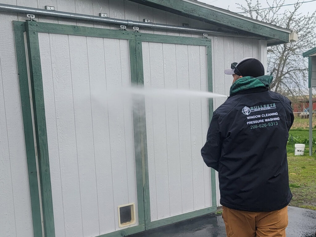 Pressure washing outbuilding on an acreage near Hauser, ID, removing dirt, grime, and mold to restore the appearance of the exterior.