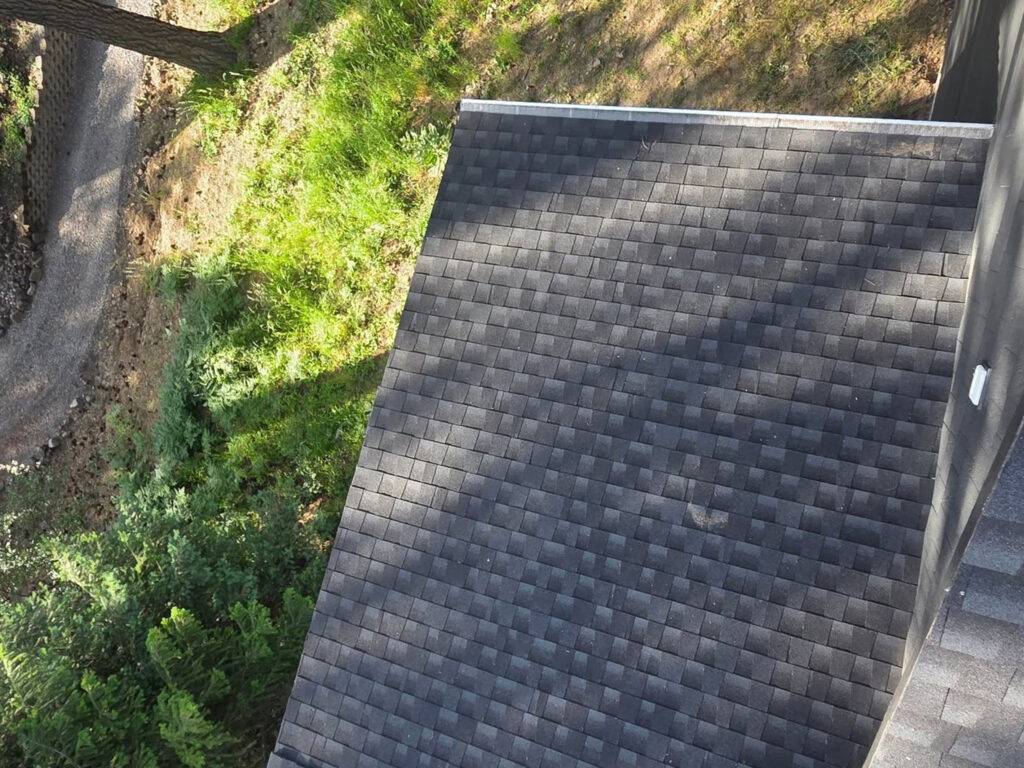 Jacob Rice, owner of Bullseye Wash Systems, cleaning the roof of a custom home in Liberty Lake, WA to ensure its long-term integrity.