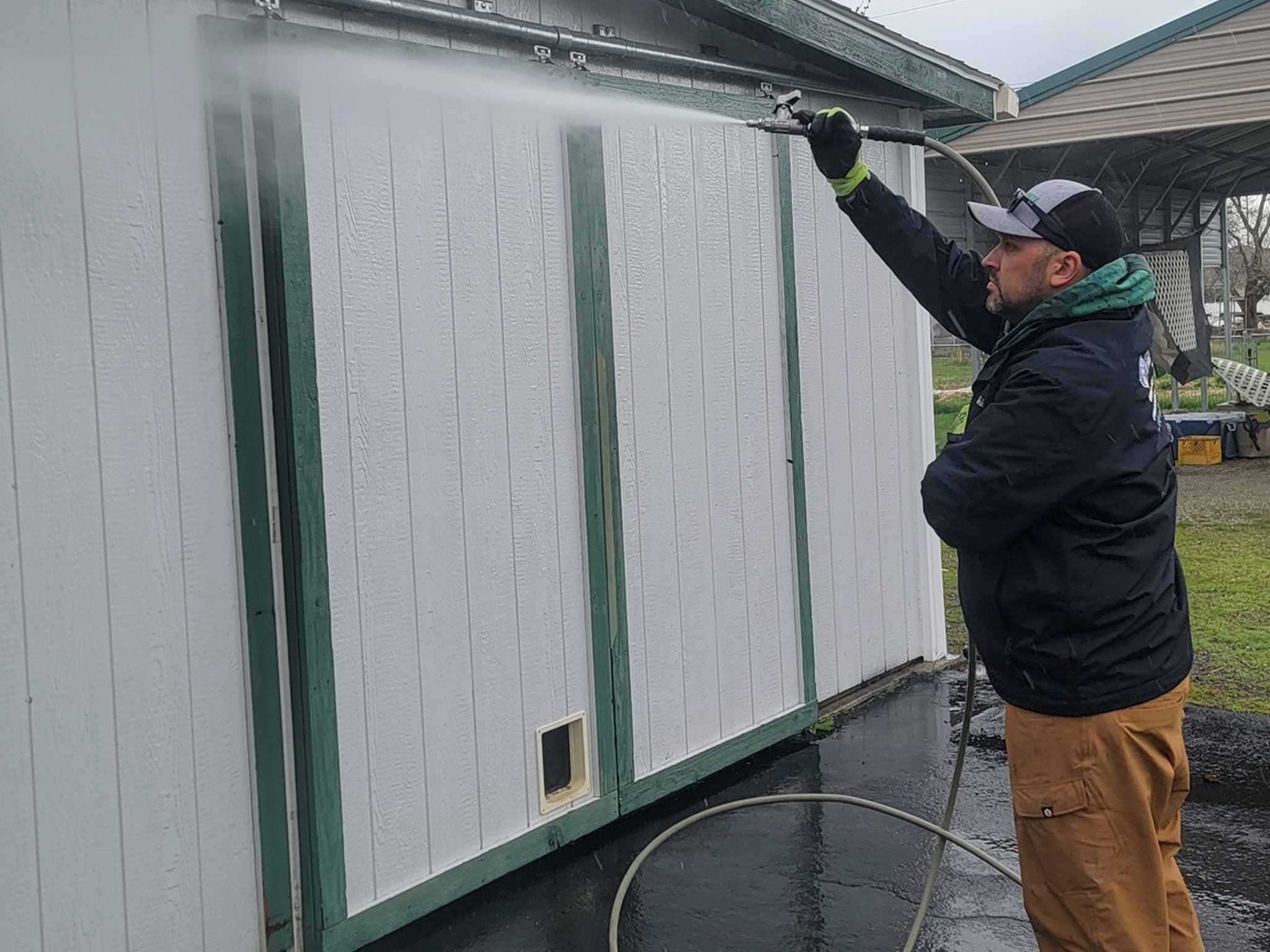 Soft washing and pressure washing of an exterior outbuilding on a residential property in Hauser, ID, cleaning the siding and removing buildup.
