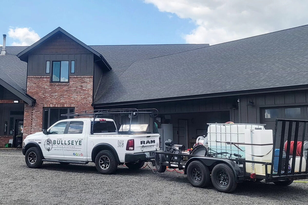 High gabled windows being washed by Bullseye Wash Systems at a large home in Post Falls, ID.