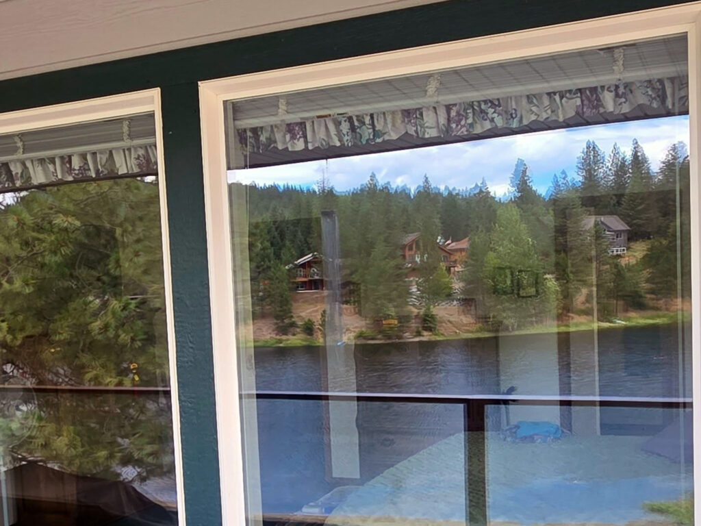 glass balcony railing cleaning near Bayview Idaho showing invisible clarity and lake views